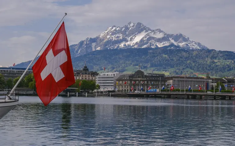 Švajcarska zastava nad jezerom u Luzernu, planina Pilatus u pozadini